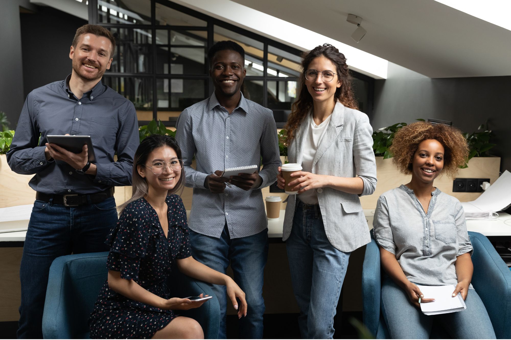 A group of diverse individuals, including foreigners, smiling at the camera. They appear to be engaged in a positive and collaborative interaction, reflecting a sense of unity, teamwork, and inclusivity in a professional or social setting. The image conveys a welcoming and friendly atmosphere, showcasing a diverse and harmonious group of people.